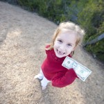 Little girl holding a dollar bill