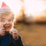 Little girl with a crown and magnifying glass