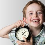 little boy holding a clock